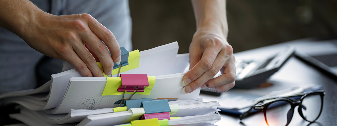 Businesswoman hands working in Stacks of paper files for searching and checking unfinished document achieves on folders papers